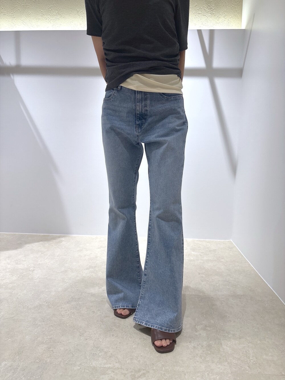 グレー系のTシャツ/カットソー、ブルー系のデニムパンツ、ブラウン系のサンダルを着用したレディースの夏コーディネートの8枚目の写真