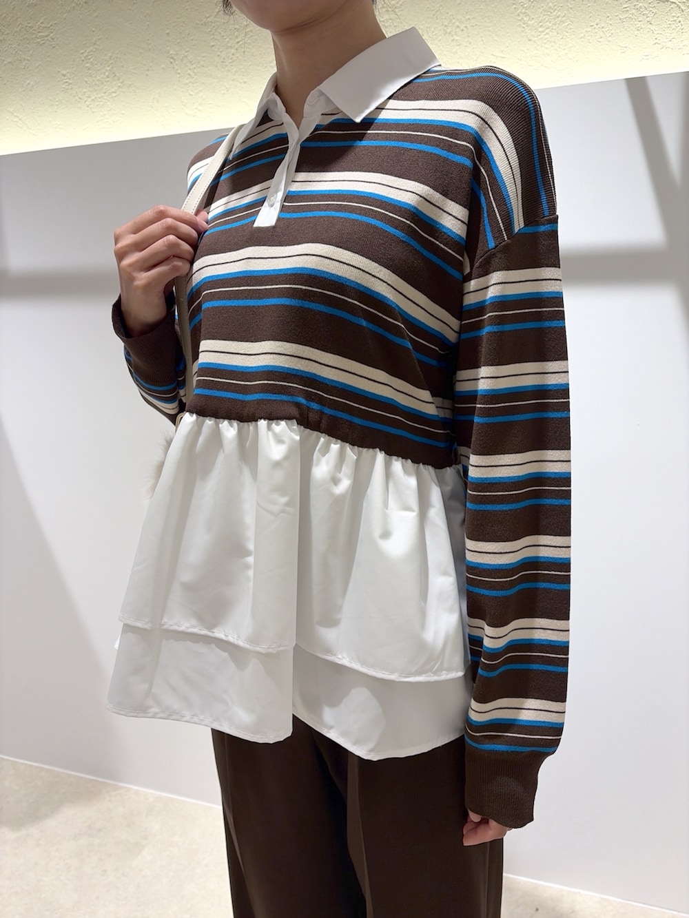 ブラウン系のニット/セーター、ブラウン系のその他パンツ、ホワイト系のショルダーバッグを着用したレディースの秋コーディネートの10枚目の写真