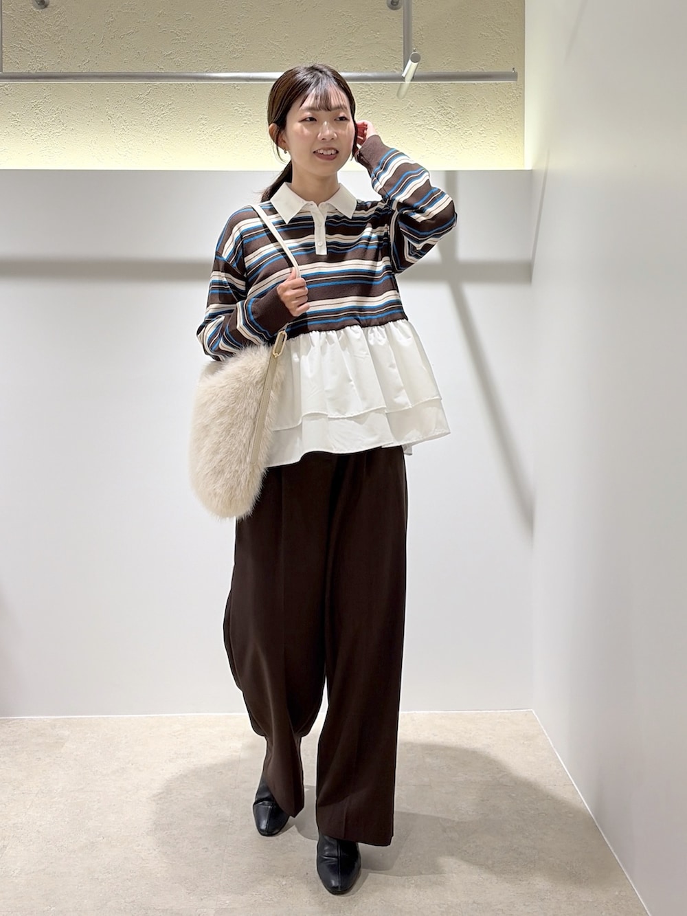 ブラウン系のニット/セーター、ブラウン系のその他パンツ、ホワイト系のショルダーバッグを着用したレディースの秋コーディネートの5枚目の写真