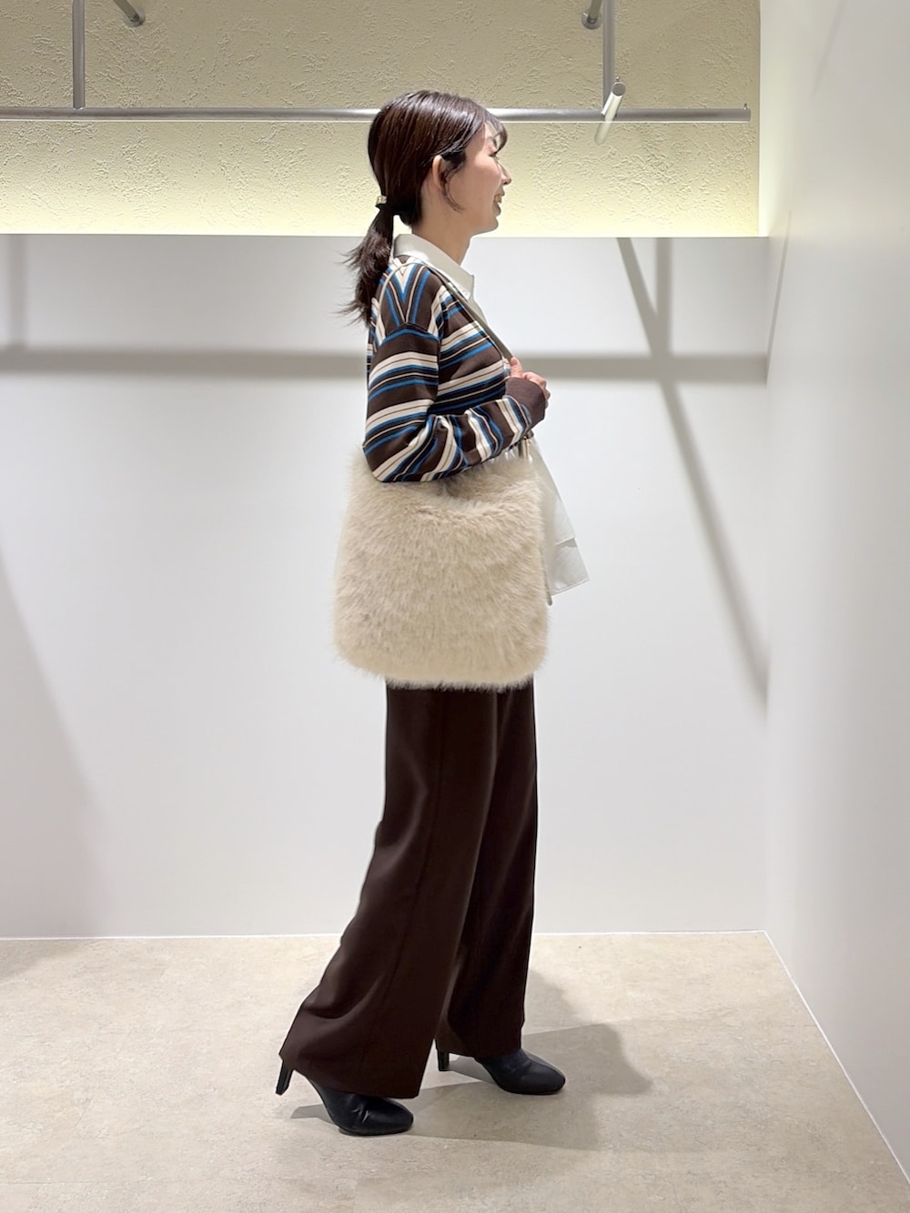 ブラウン系のニット/セーター、ブラウン系のその他パンツ、ホワイト系のショルダーバッグを着用したレディースの秋コーディネートの4枚目の写真