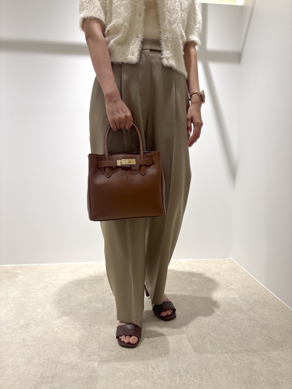 ホワイト系のニット/セーター、ベージュ系のその他パンツ、イエロー系のトートバッグを着用したレディースの夏コーディネートの9枚目の写真
