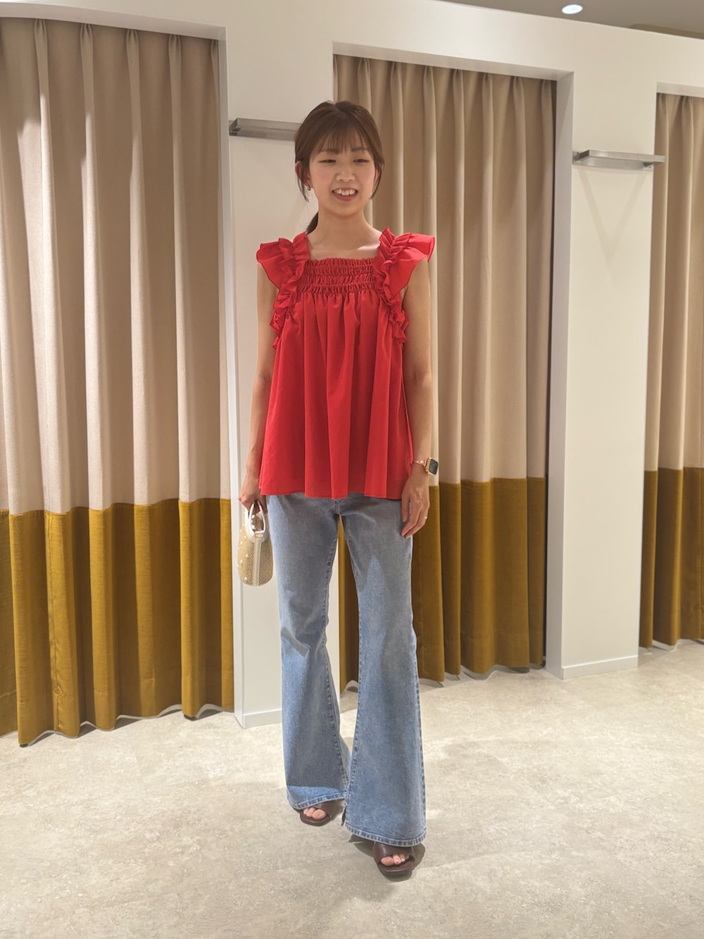 レッド系のシャツ/ブラウス、ベージュ系のバッグ、ブラウン系のサンダルを着用したレディースの夏コーディネートの2枚目の写真