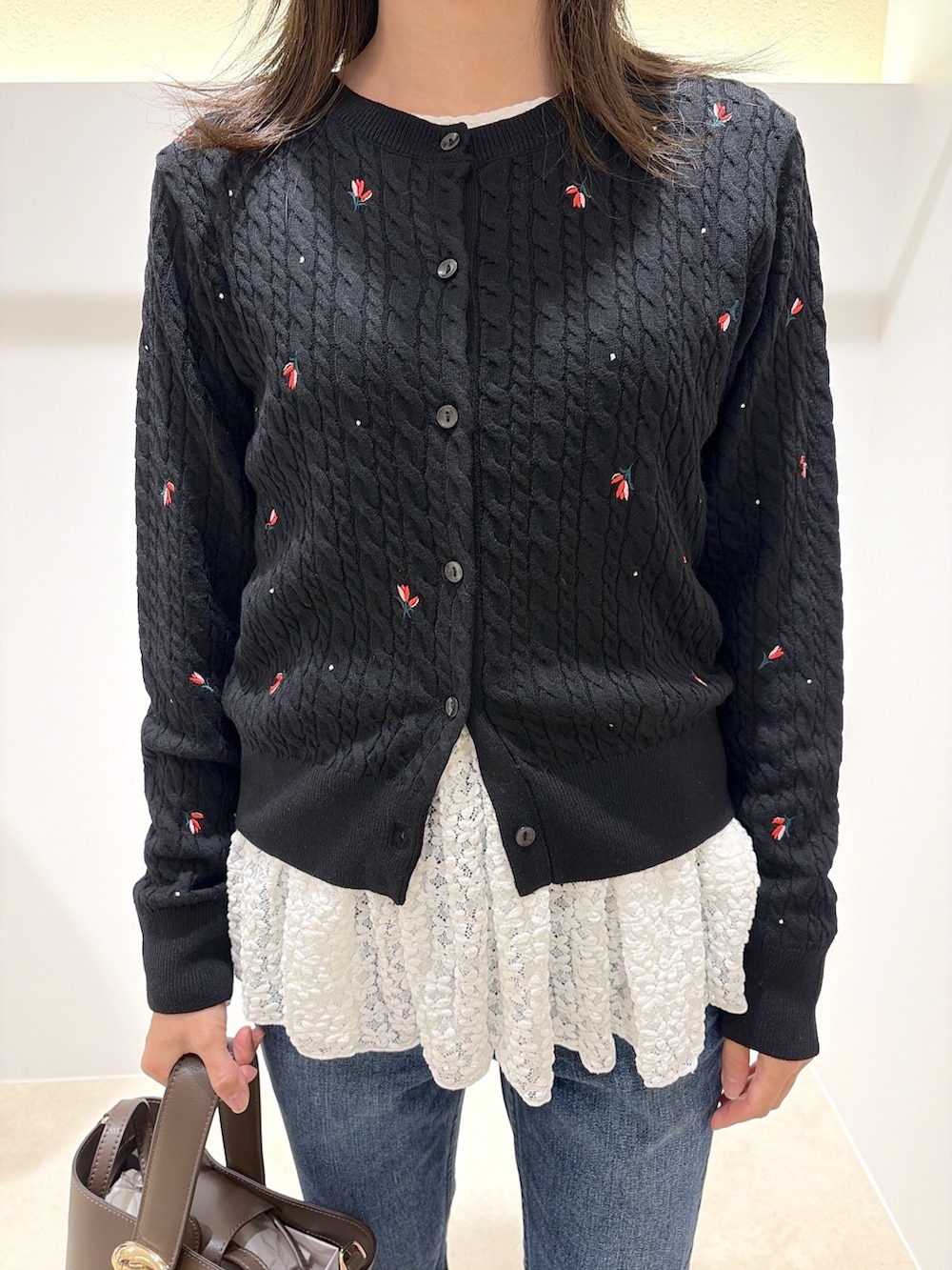 ブラック系のカーディガン/ボレロ、ホワイト系のTシャツ/カットソー、ブルー系のデニムパンツを着用したレディースの秋コーディネートの4枚目の写真