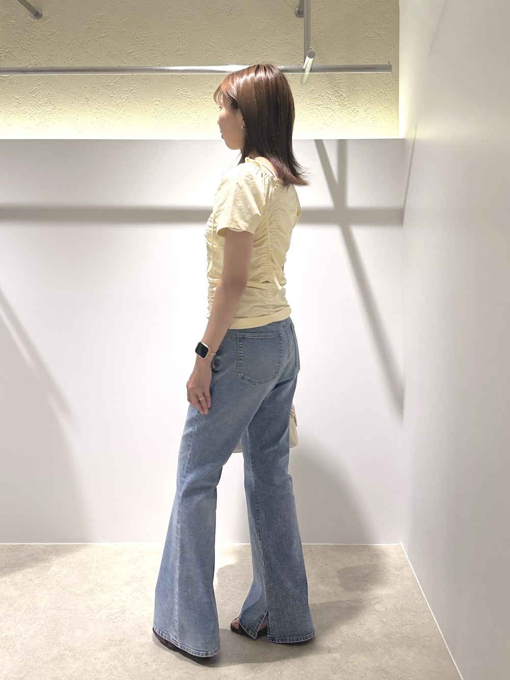 イエロー系のTシャツ/カットソー、ブルー系のデニムパンツ、ブラウン系のサンダルを着用したレディースの夏コーディネートの2枚目の写真