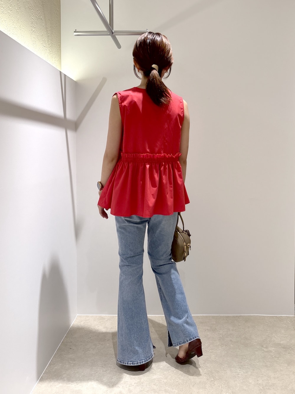 レッド系のシャツ/ブラウス、ブルー系のデニムパンツ、ブラック系のボストンバッグを着用したレディースの夏コーディネートの3枚目の写真