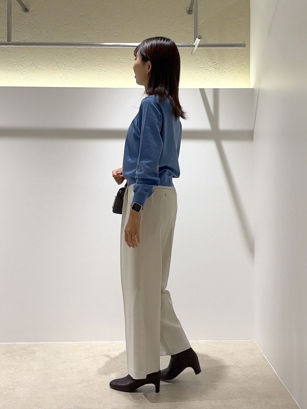 ブルー系のカーディガン/ボレロ、ホワイト系のその他パンツ、ブラウン系のブーツを着用したレディースの秋コーディネートの2枚目の写真
