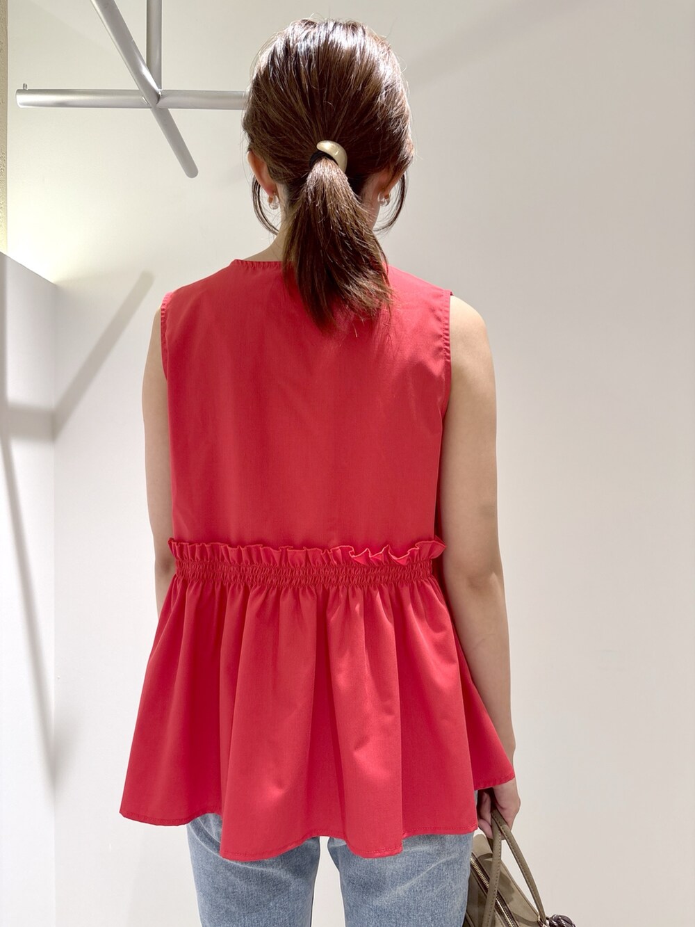 レッド系のシャツ/ブラウス、ブルー系のデニムパンツ、ブラック系のボストンバッグを着用したレディースの夏コーディネートの6枚目の写真