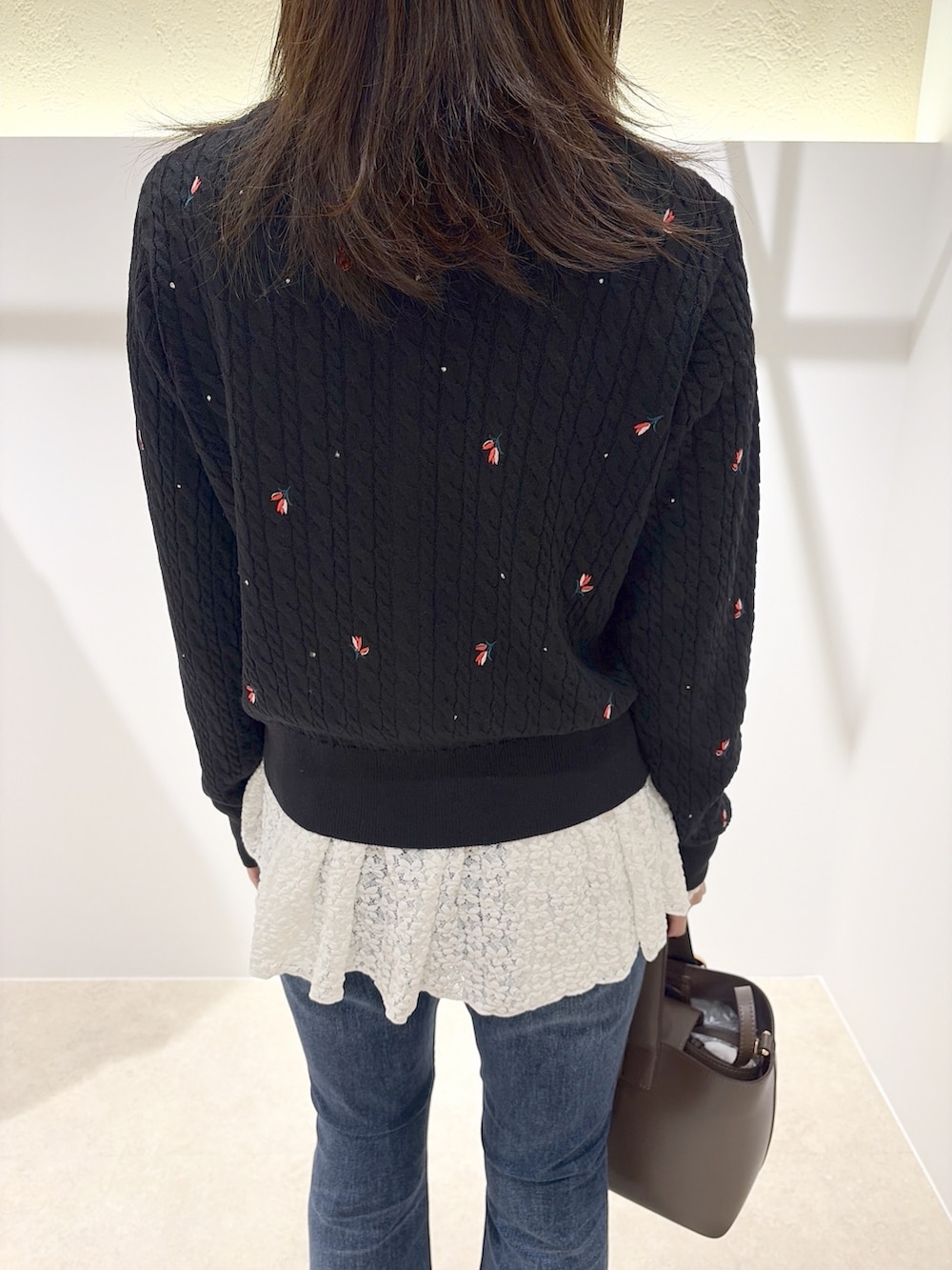 ブラック系のカーディガン/ボレロ、ホワイト系のTシャツ/カットソー、ブルー系のデニムパンツを着用したレディースの秋コーディネートの5枚目の写真