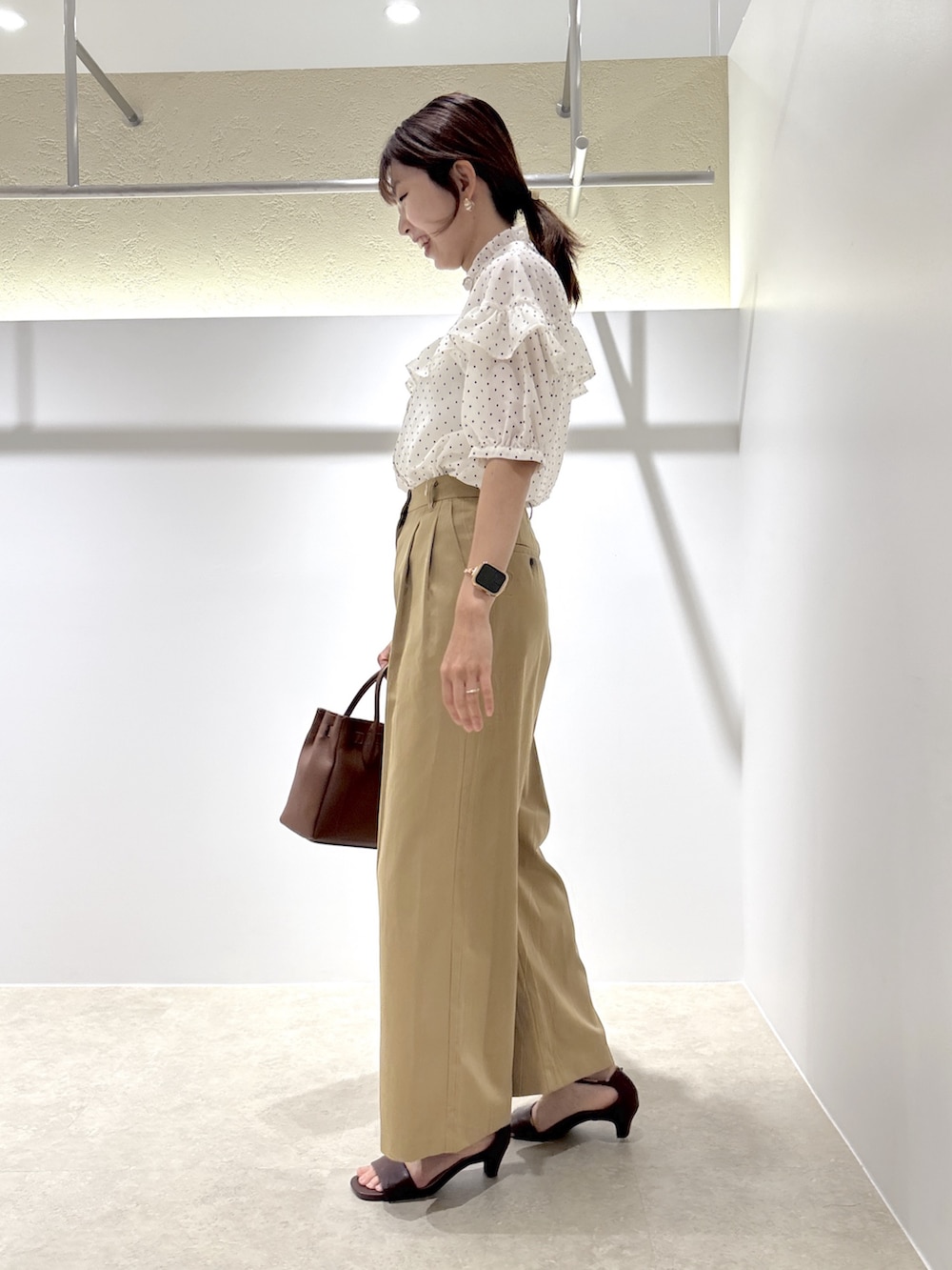 ホワイト系のシャツ/ブラウス、ベージュ系のその他パンツ、ブラウン系のサンダルを着用したレディースの夏コーディネートの4枚目の写真