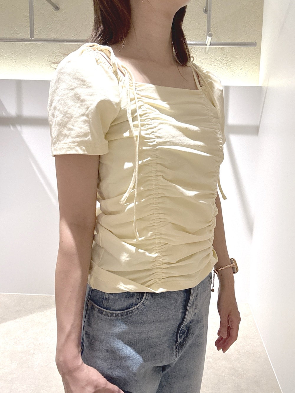 イエロー系のTシャツ/カットソー、ブルー系のデニムパンツ、ブラウン系のサンダルを着用したレディースの夏コーディネートの5枚目の写真