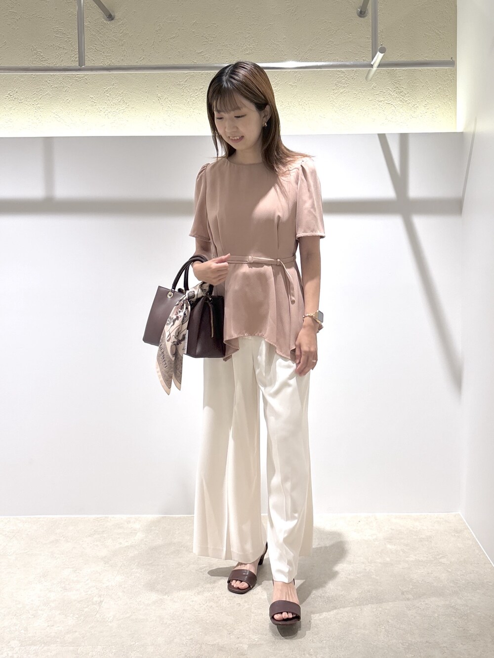 ピンク系のシャツ/ブラウス、ホワイト系のその他パンツ、ブラウン系のサンダルを着用したレディースの夏コーディネートの2枚目の写真