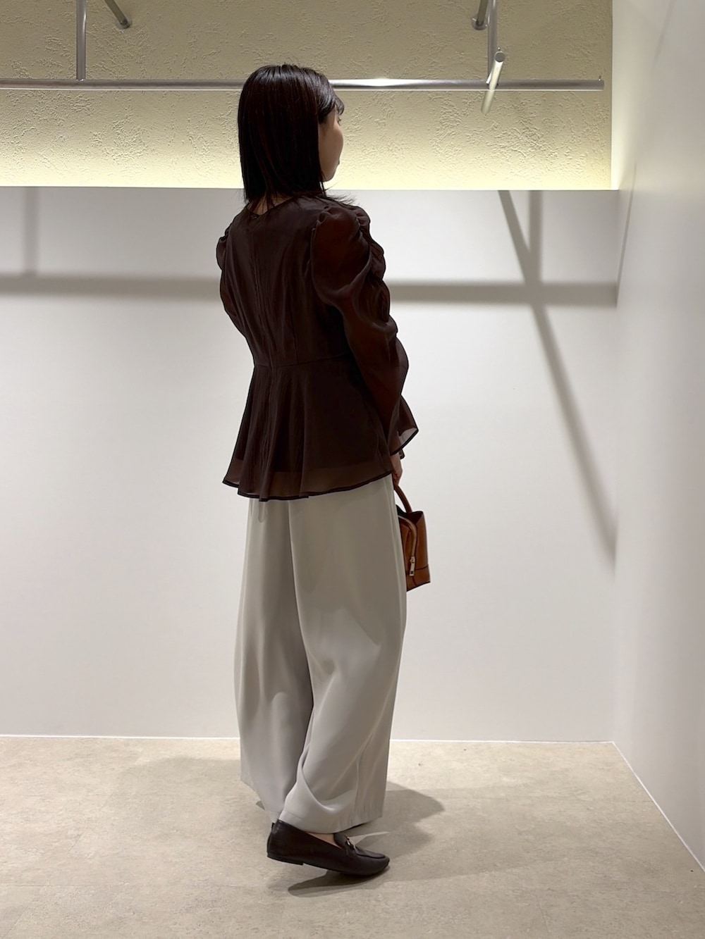 ブラウン系のシャツ/ブラウス、ベージュ系のその他パンツ、ブラック系のトートバッグを着用したレディースの秋コーディネートの3枚目の写真