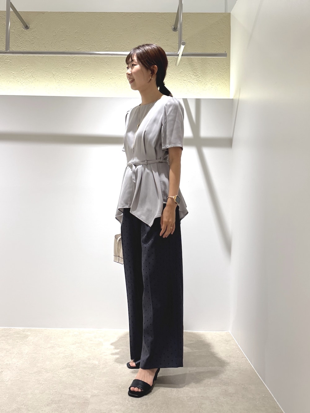 グレー系のシャツ/ブラウス、グレー系のその他パンツ、ブラック系のサンダルを着用したレディースの夏コーディネートの2枚目の写真