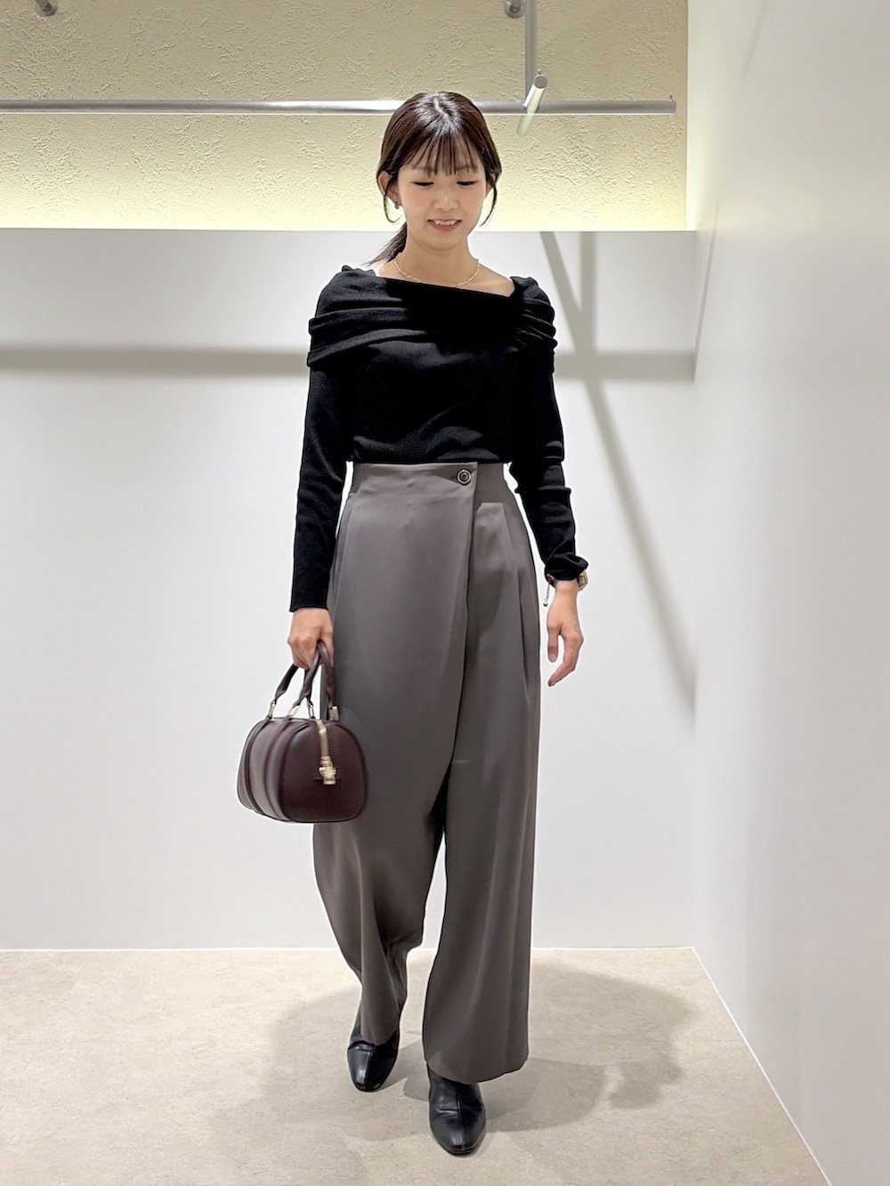 ブラック系のニット/セーター、グレー系のその他パンツ、ブラウン系のブーツを着用したレディースの秋コーディネートの4枚目の写真