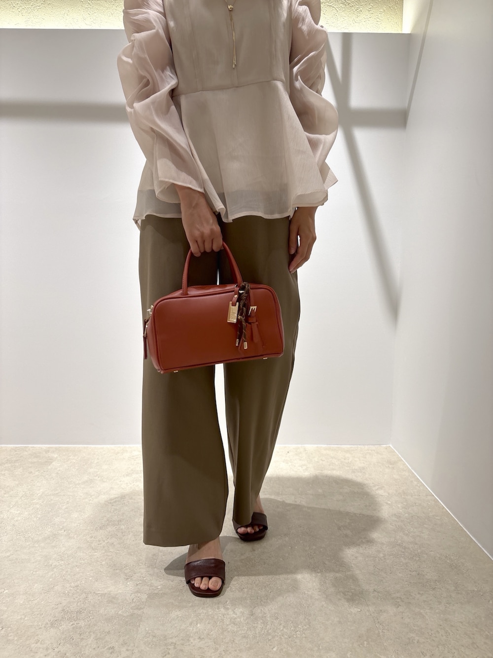ベージュ系のシャツ/ブラウス、イエロー系のその他パンツ、ブラウン系のサンダルを着用したレディースの秋コーディネートの8枚目の写真