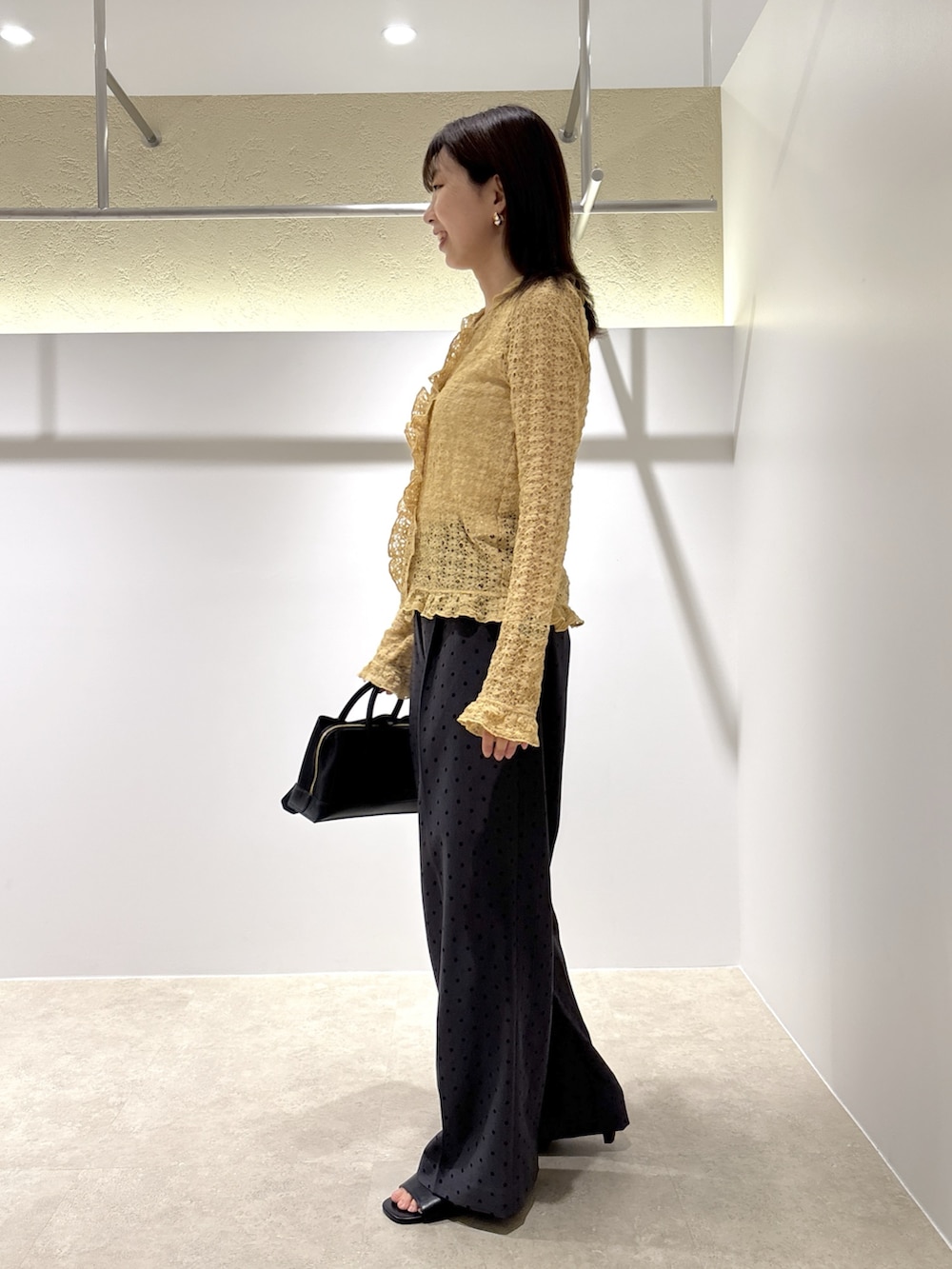 イエロー系のカーディガン/ボレロ、グレー系のその他パンツ、ブラック系のサンダルを着用したレディースの夏コーディネートの2枚目の写真