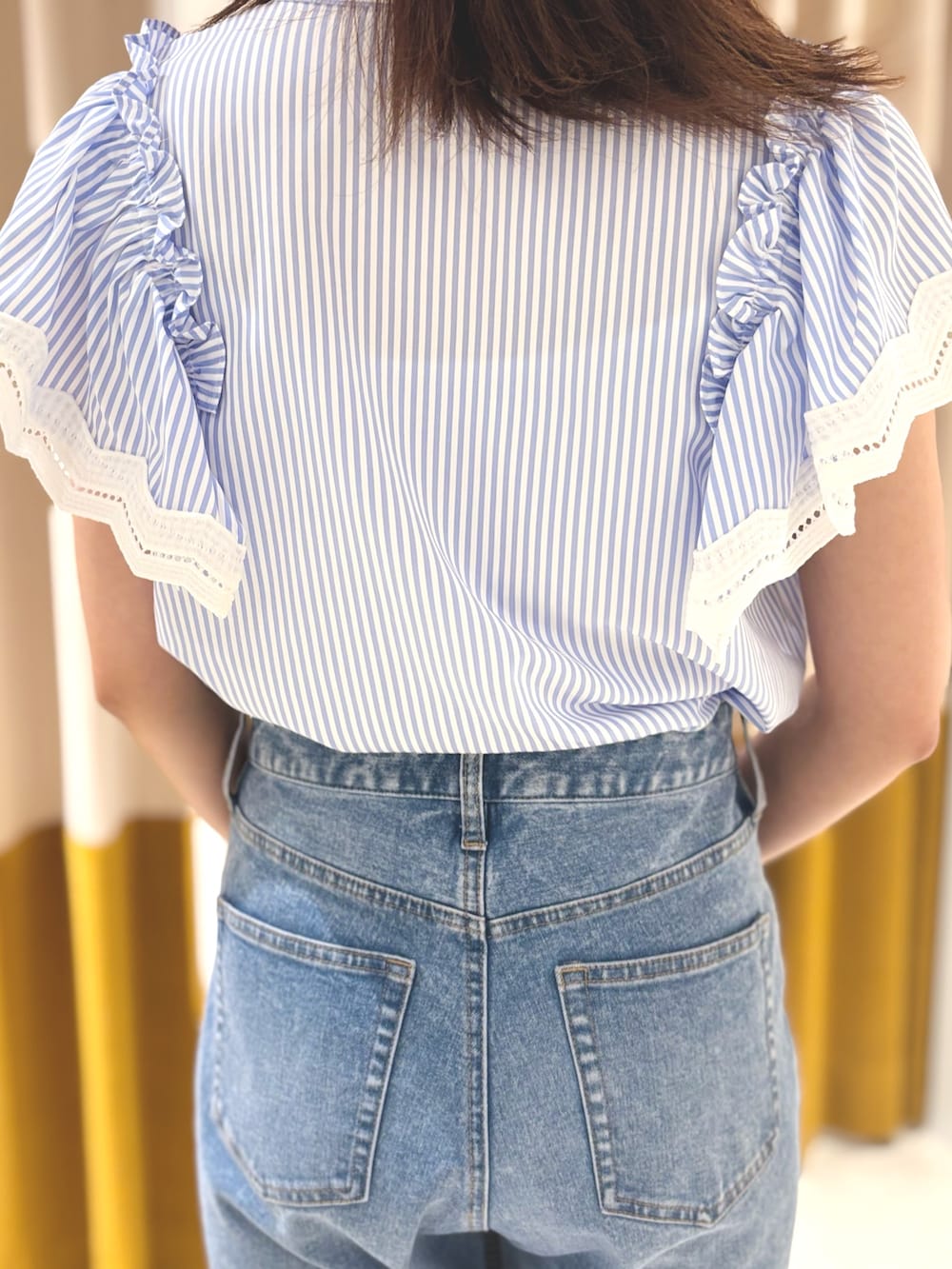 ブラウン系のサンダル、ブルー系のデニムパンツ、シルバー系のハンドバッグを着用したレディースの夏コーディネートの6枚目の写真