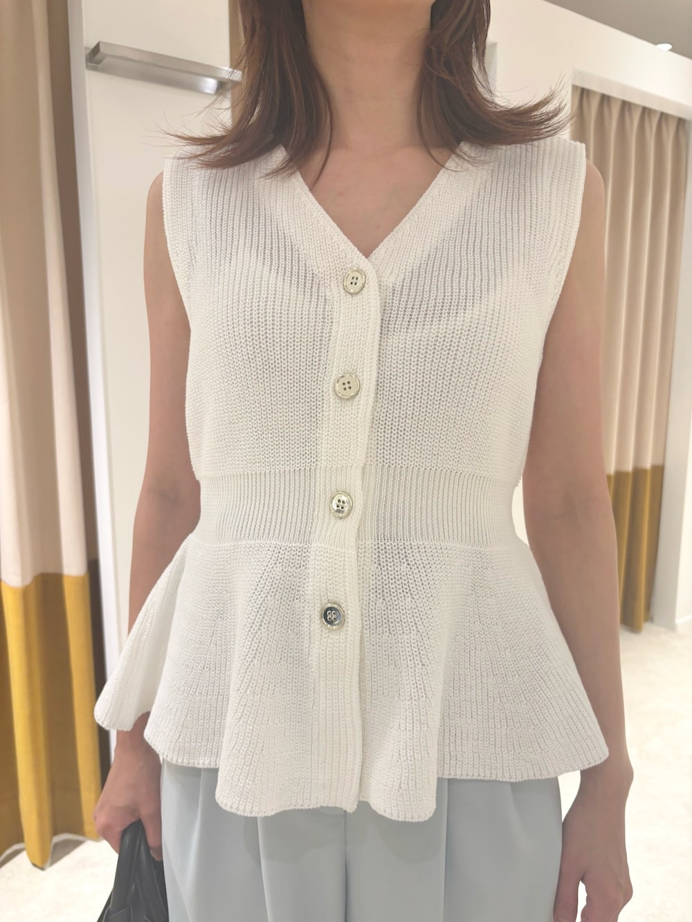 ホワイト系のベスト、ブルー系のその他パンツ、ブラック系のサンダルを着用したレディースの夏コーディネートの5枚目の写真