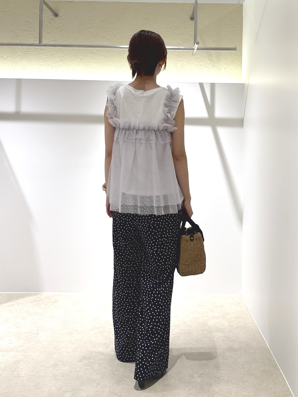 ホワイト系のTシャツ/カットソー、ブラック系のその他パンツ、ベージュ系のかごバッグを着用したレディースの夏コーディネートの3枚目の写真