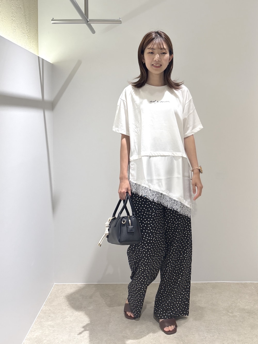 ホワイト系のTシャツ/カットソー、ブラック系のサンダル、ブラック系のボストンバッグを着用したレディースの夏コーディネートの5枚目の写真