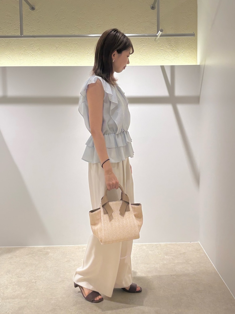 ブルー系のシャツ/ブラウス、ホワイト系のその他パンツ、ホワイト系のトートバッグを着用したレディースの夏コーディネートの4枚目の写真