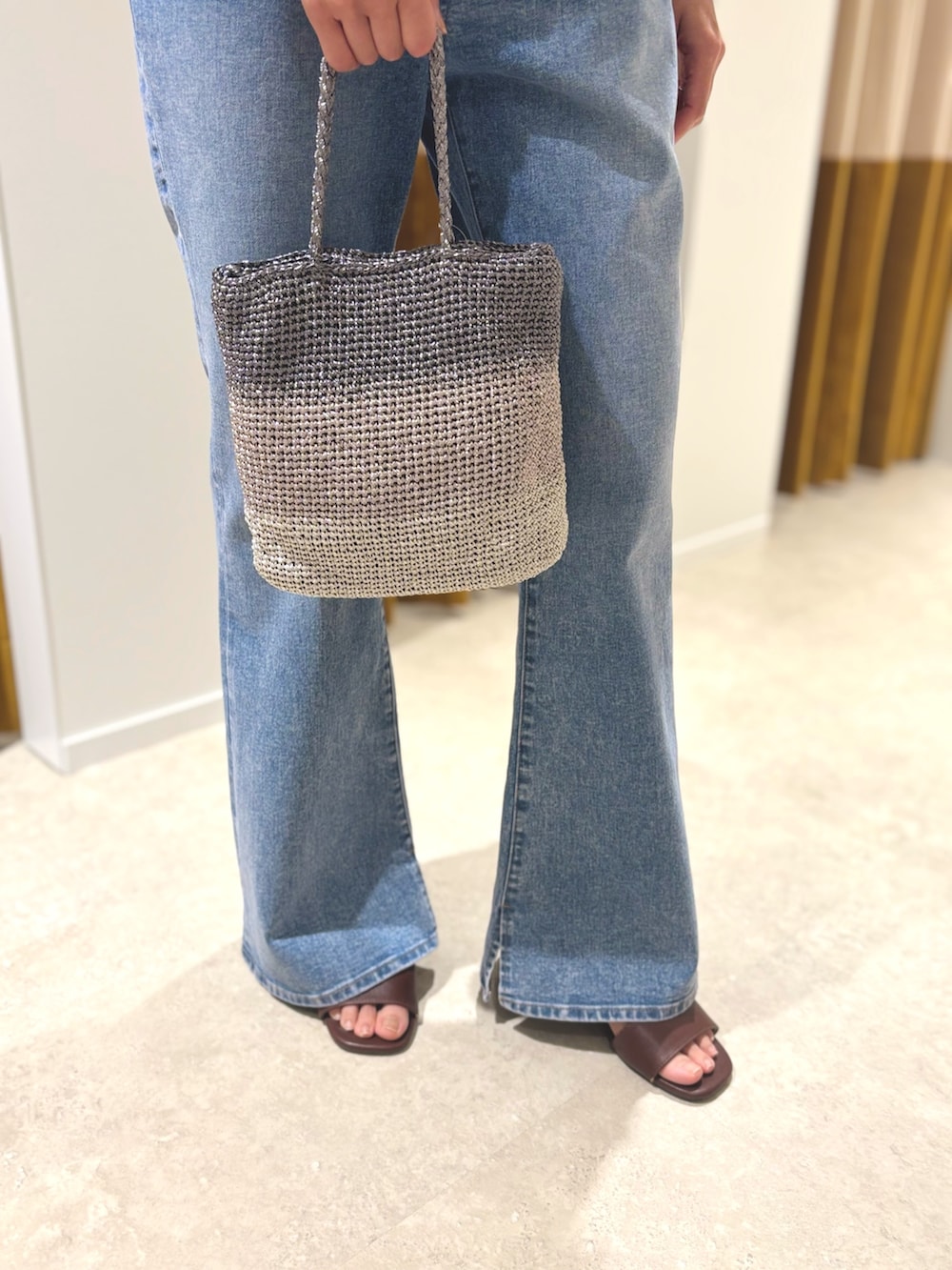 ブラウン系のサンダル、ブルー系のデニムパンツ、シルバー系のハンドバッグを着用したレディースの夏コーディネートの7枚目の写真