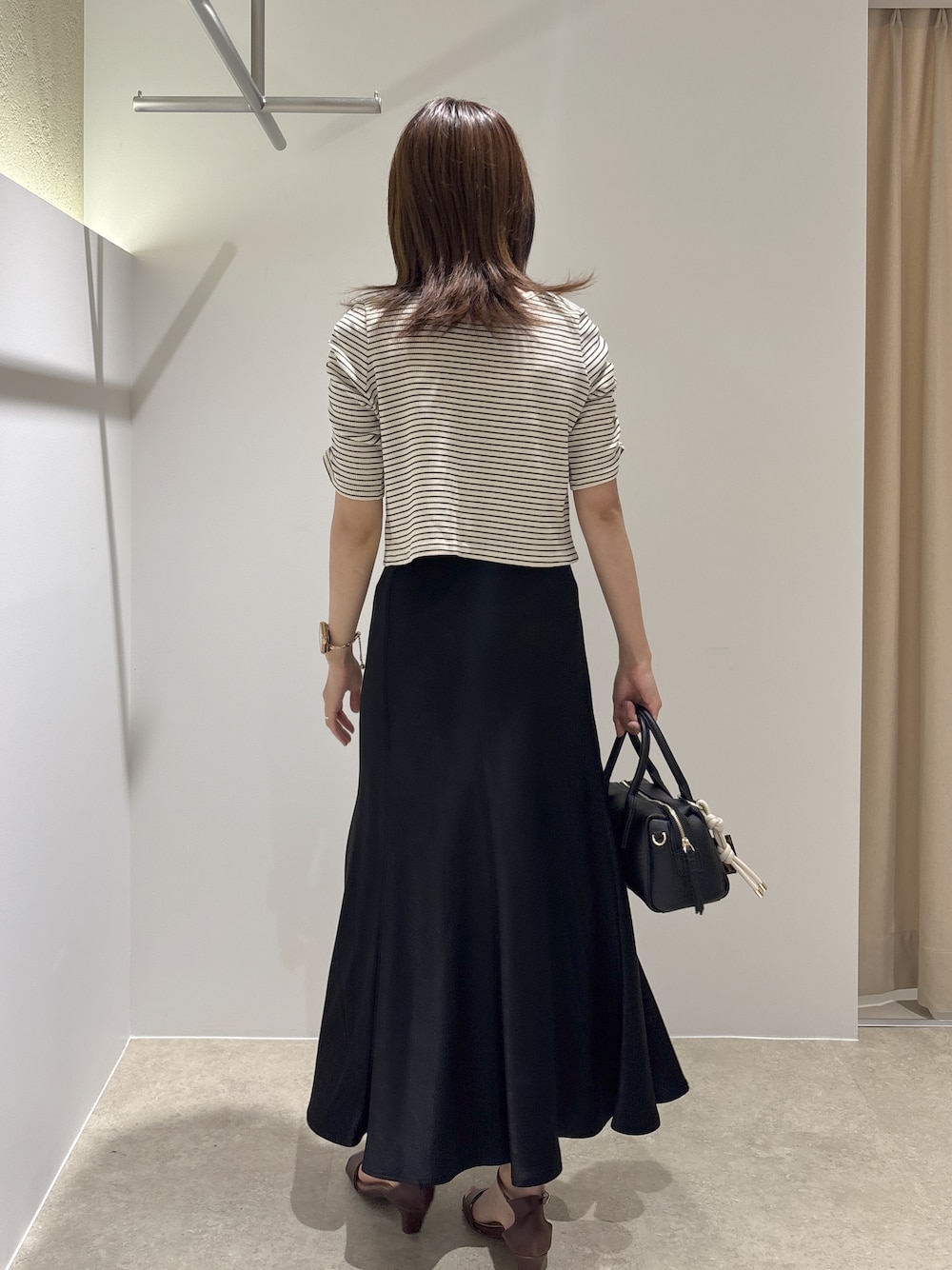 ホワイト系のTシャツ/カットソー、ブラウン系のサンダル、ブラック系のボストンバッグを着用したレディースの夏コーディネートの3枚目の写真