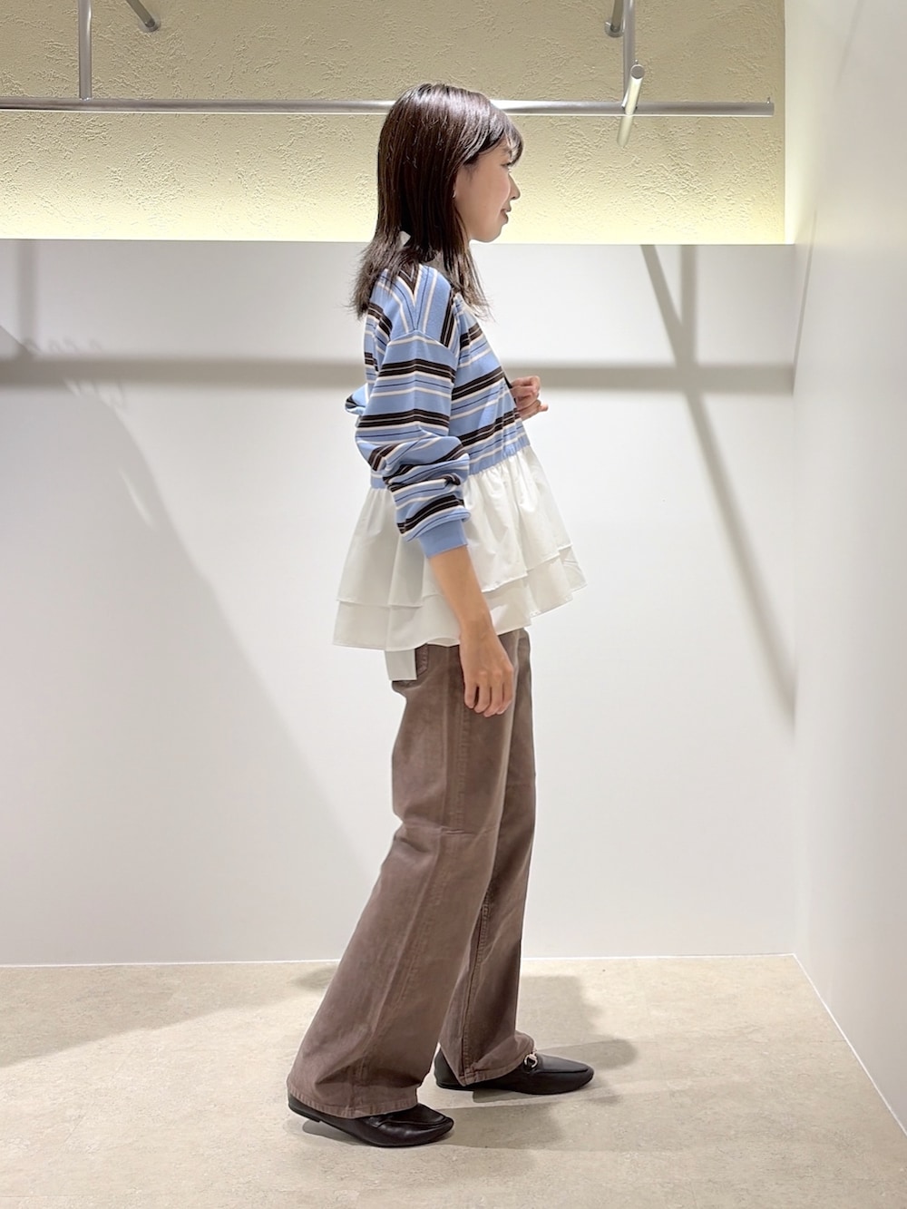 ブルー系のニット/セーター、ブラウン系のその他パンツ、ブラウン系のローファーを着用したレディースの秋コーディネートの4枚目の写真