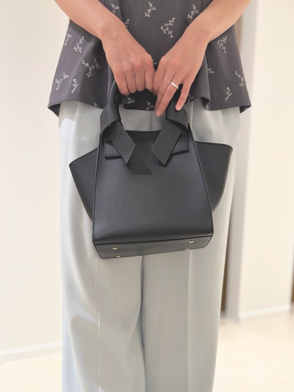 グレー系のシャツ/ブラウス、ブラック系のトートバッグ、ブラック系のサンダルを着用したレディースの夏コーディネートの8枚目の写真