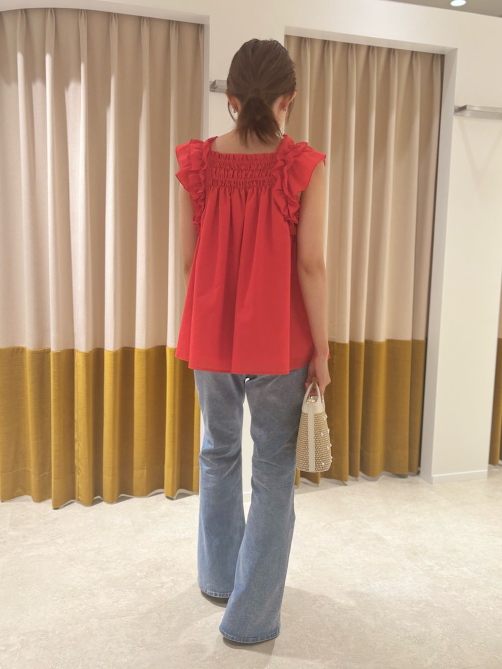 レッド系のシャツ/ブラウス、ベージュ系のバッグ、ブラウン系のサンダルを着用したレディースの夏コーディネートの4枚目の写真