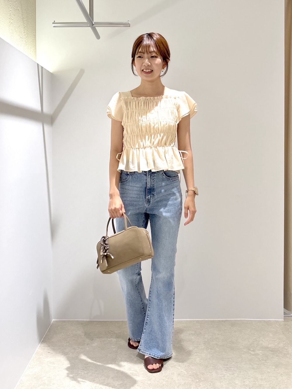 ピンク系のシャツ/ブラウス、ブルー系のデニムパンツ、ブラック系のボストンバッグを着用したレディースの夏コーディネートの2枚目の写真