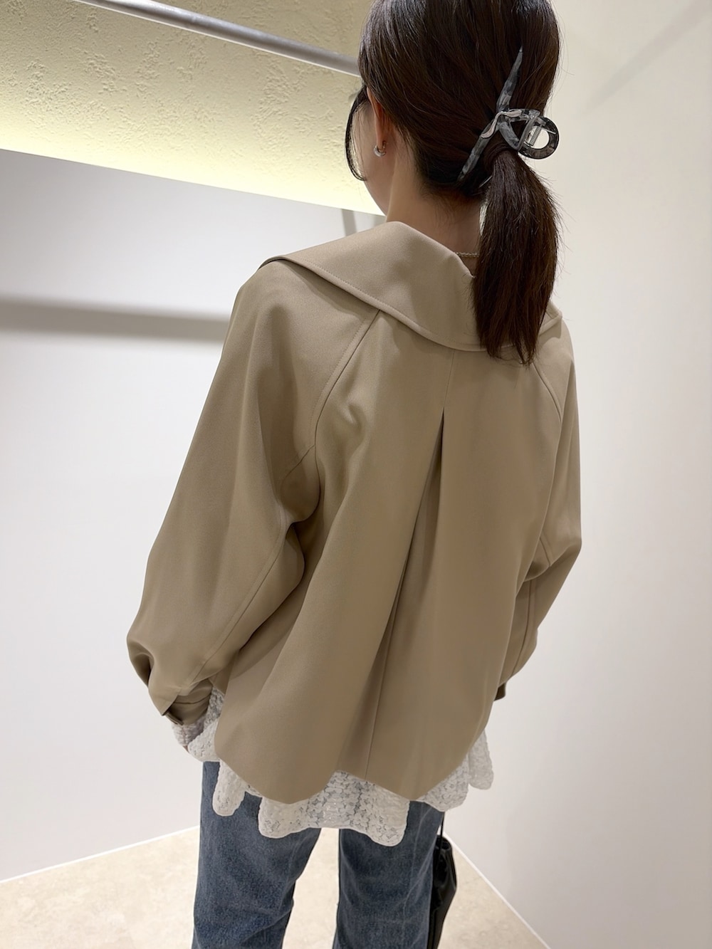 ベージュ系のトレンチコート、ホワイト系のTシャツ/カットソー、ブラック系のデニムパンツを着用したレディースの秋コーディネートの9枚目の写真