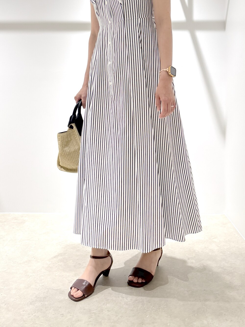 ホワイト系のワンピース、ベージュ系のトートバッグ、ブラウン系のサンダルを着用したレディースの夏コーディネートの8枚目の写真