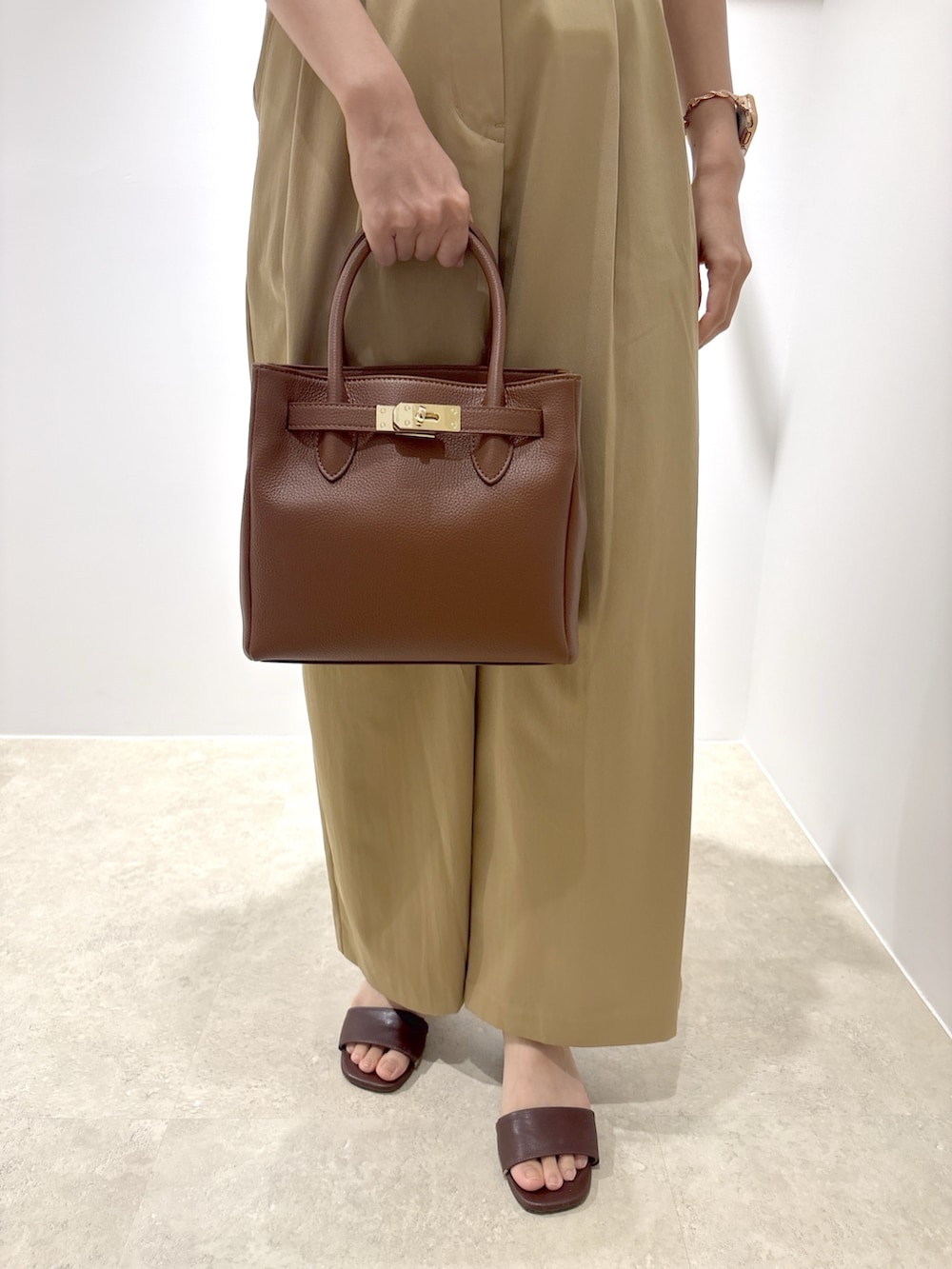 ホワイト系のシャツ/ブラウス、ベージュ系のその他パンツ、ブラウン系のサンダルを着用したレディースの夏コーディネートの7枚目の写真
