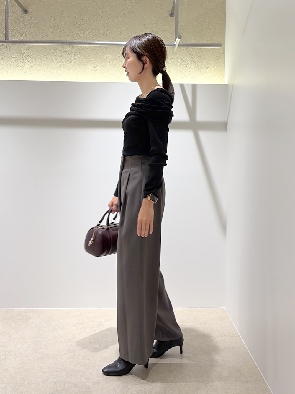 ブラック系のニット/セーター、グレー系のその他パンツ、ブラウン系のブーツを着用したレディースの秋コーディネートの2枚目の写真
