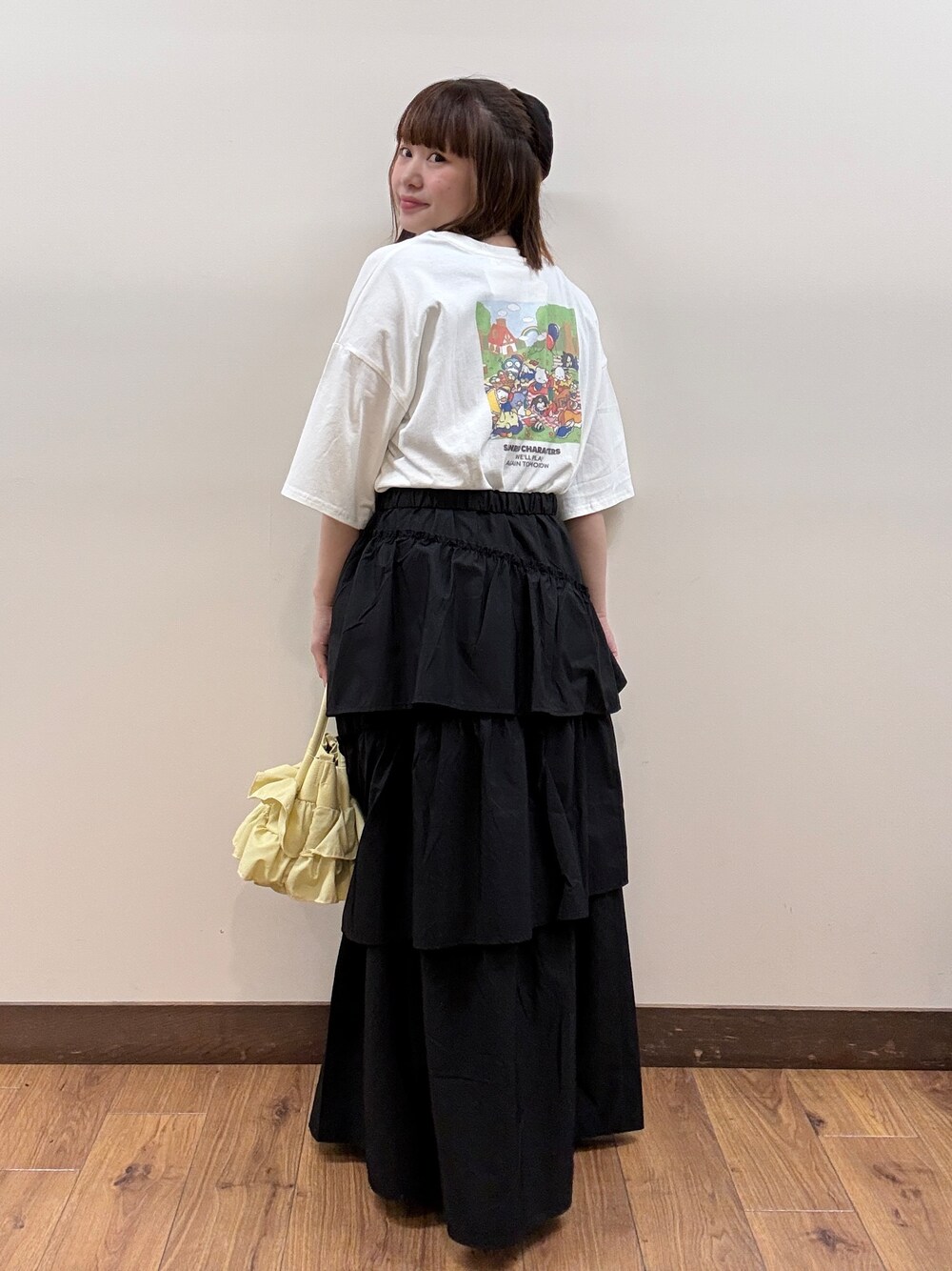 ホワイト系のTシャツ/カットソー、ブラック系のスカート、イエロー系のショルダーバッグを着用したレディースの春コーディネートの3枚目の写真