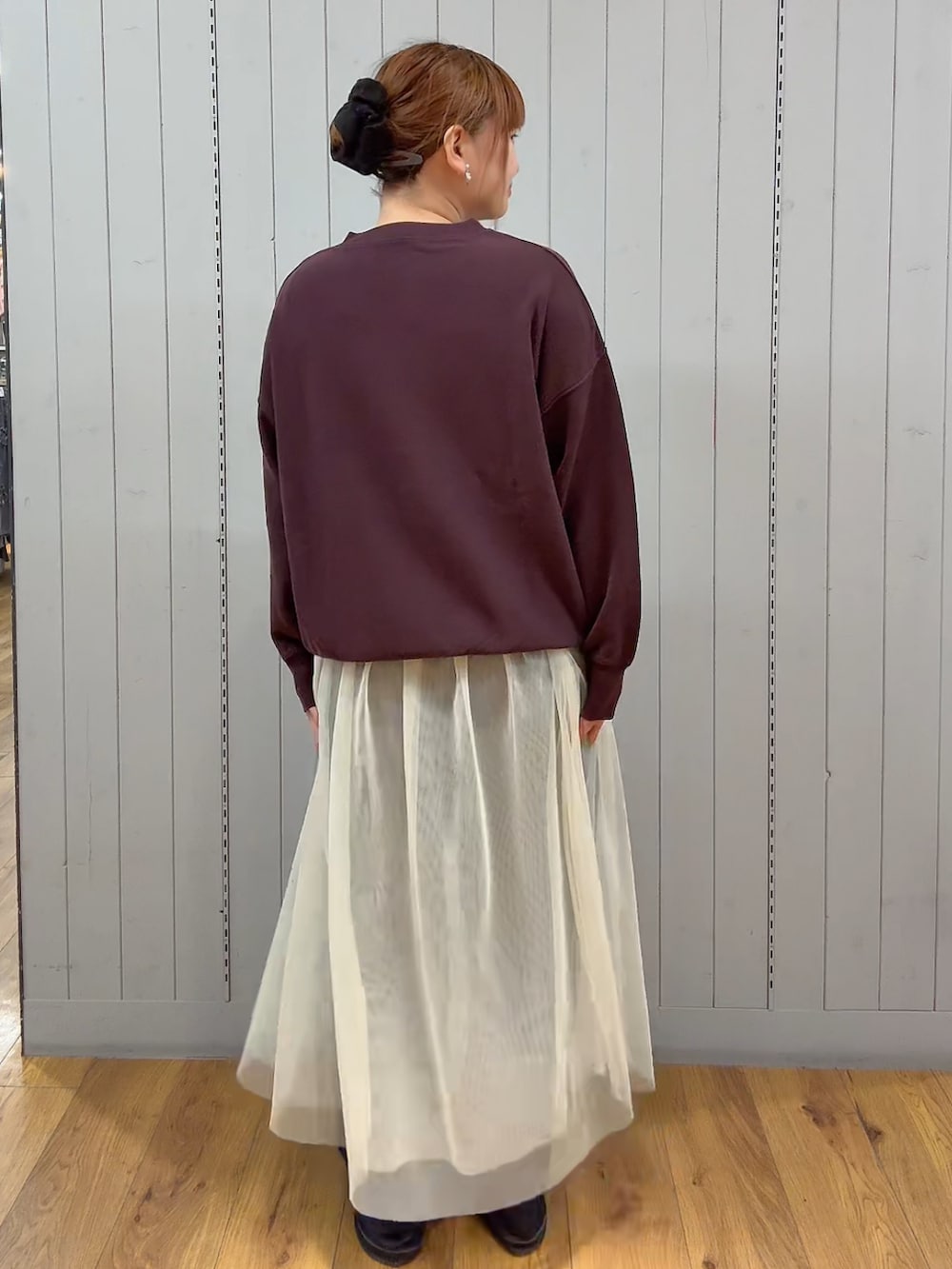 レッド系のスウェット、ブルー系のデニムパンツを着用したレディースの秋コーディネートの3枚目の写真
