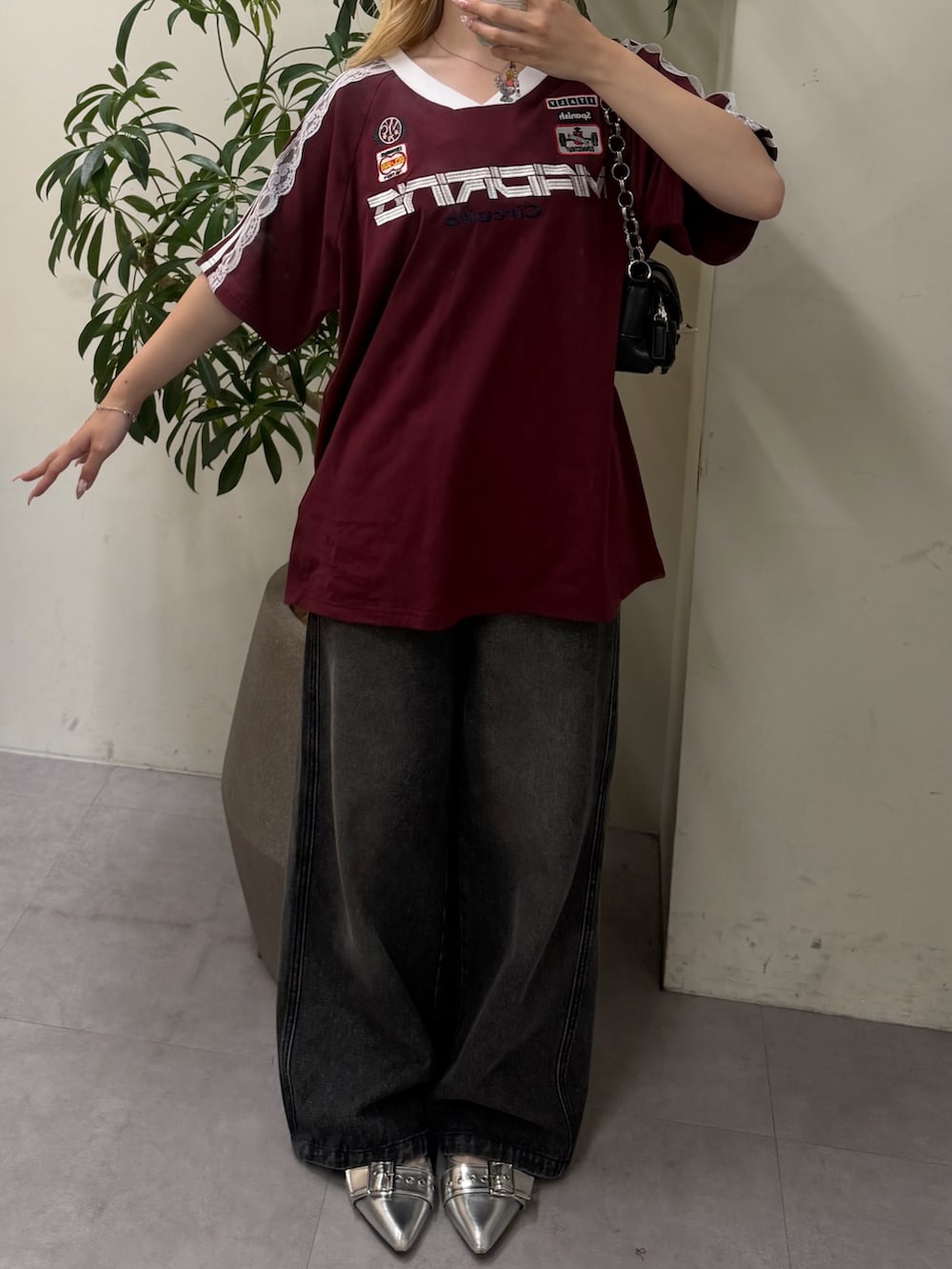 ブラック系のデニムパンツ、ブラック系のショルダーバッグ、レッド系のTシャツ/カットソーを着用したレディースの夏コーディネートの2枚目の写真