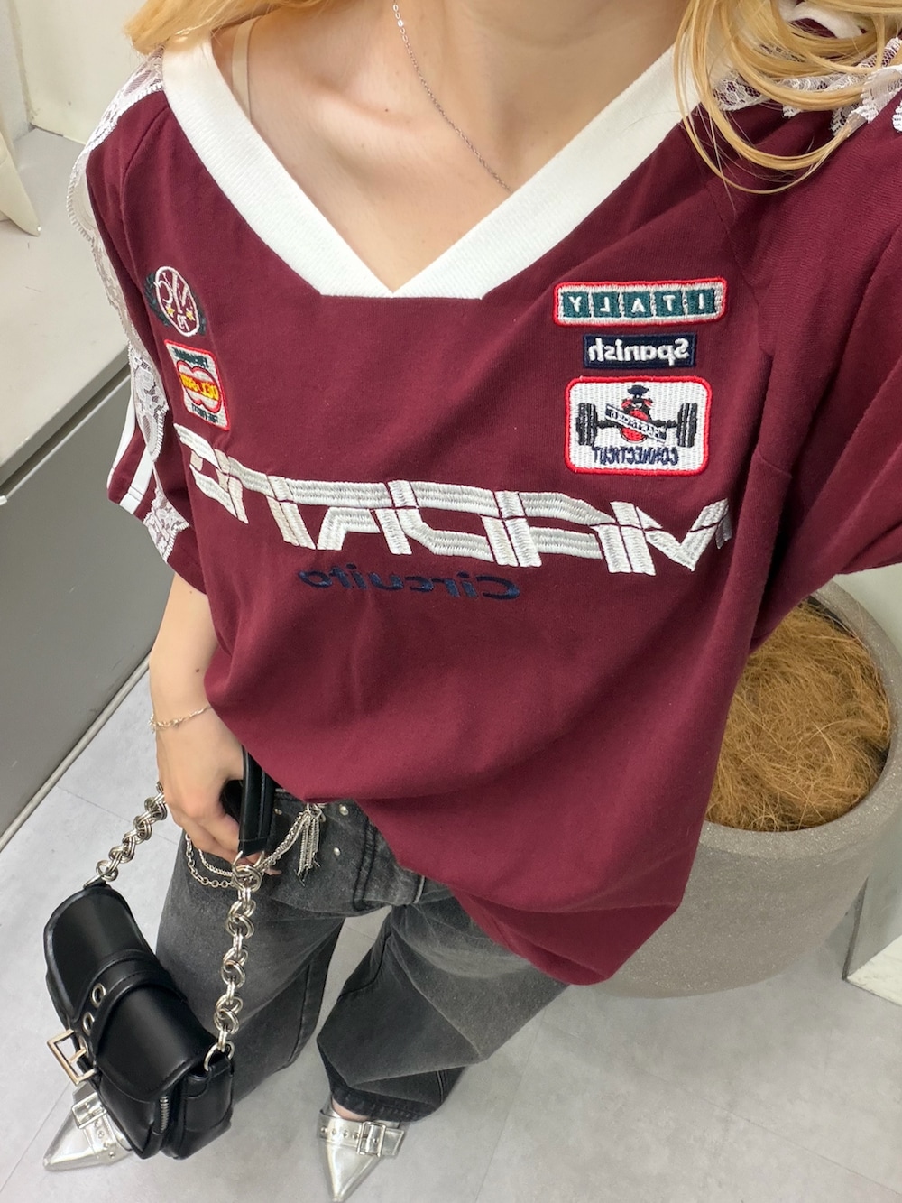ブラック系のデニムパンツ、ブラック系のショルダーバッグ、レッド系のTシャツ/カットソーを着用したレディースの夏コーディネートの3枚目の写真