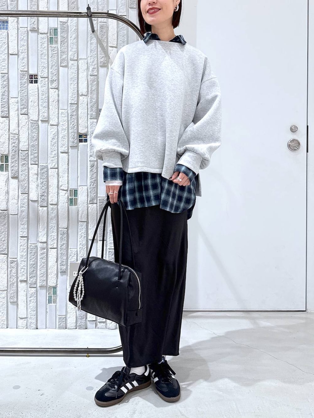 ホワイト系のTシャツ/カットソー、ブラック系のスカート、ブラック系のボストンバッグを着用したレディースの冬コーディネートの3枚目の写真