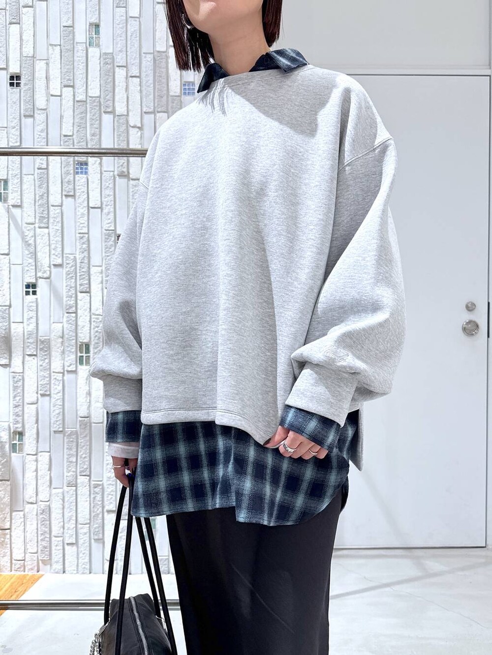 ホワイト系のTシャツ/カットソー、ブラック系のスカート、ブラック系のボストンバッグを着用したレディースの冬コーディネートの6枚目の写真