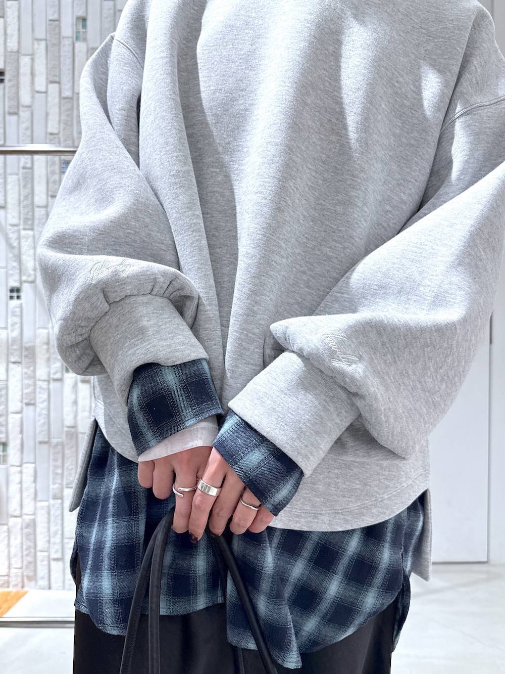 ホワイト系のTシャツ/カットソー、ブラック系のスカート、ブラック系のボストンバッグを着用したレディースの冬コーディネートの7枚目の写真