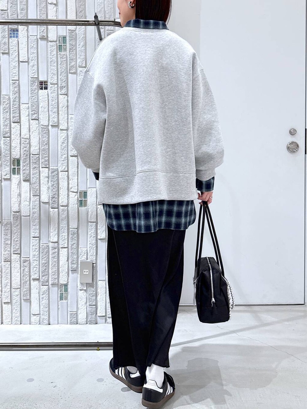 ホワイト系のTシャツ/カットソー、ブラック系のスカート、ブラック系のボストンバッグを着用したレディースの冬コーディネートの5枚目の写真