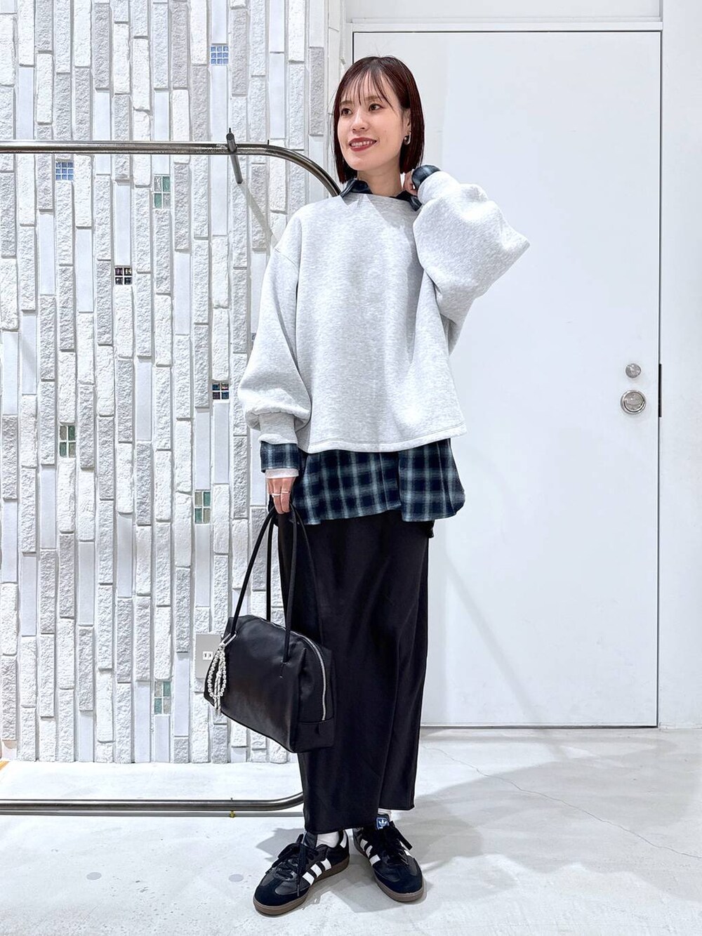 ホワイト系のTシャツ/カットソー、ブラック系のスカート、ブラック系のボストンバッグを着用したレディースの冬コーディネートの2枚目の写真