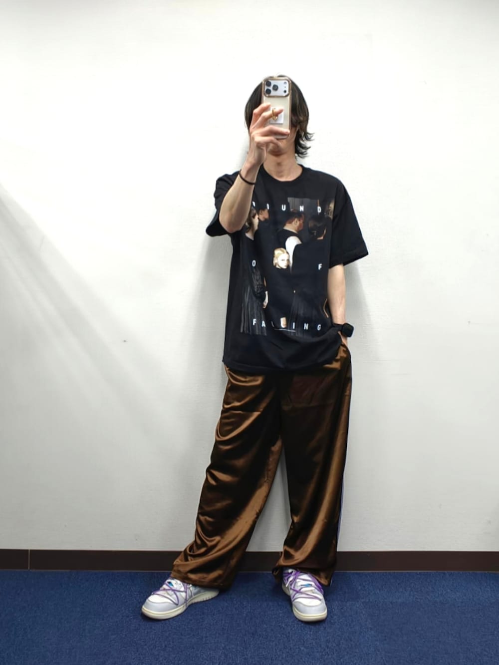 ブラック系のTシャツ/カットソー、ブラウン系のスラックス、ホワイト系のスニーカーを着用したメンズの春コーディネートの2枚目の写真