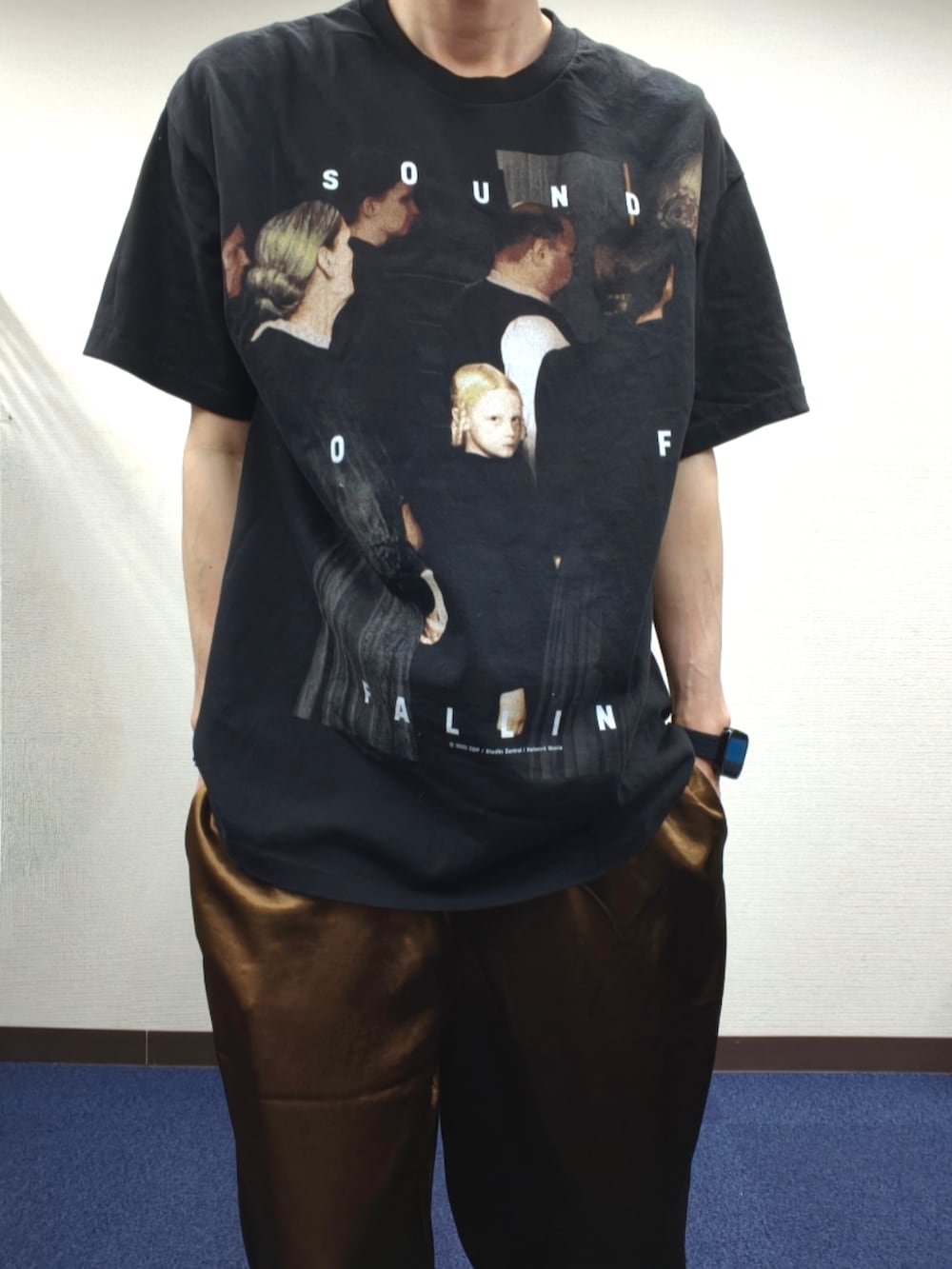 ブラック系のTシャツ/カットソー、ブラウン系のスラックス、ホワイト系のスニーカーを着用したメンズの春コーディネートの3枚目の写真