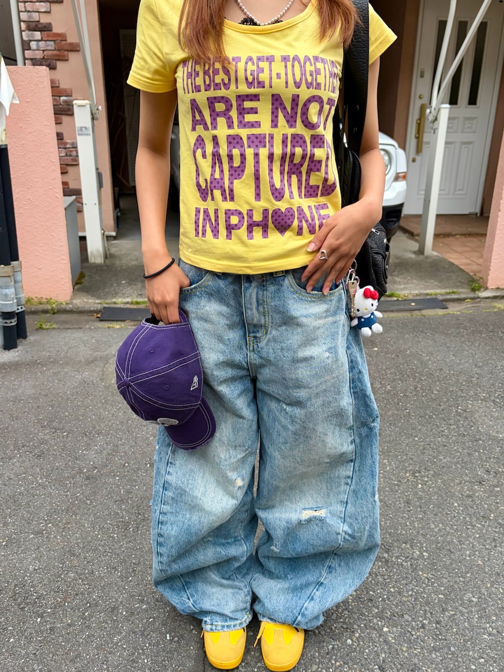 イエロー系のTシャツ/カットソー、ブルー系のデニムパンツ、イエロー系のスニーカーを着用したレディースの夏コーディネートの4枚目の写真