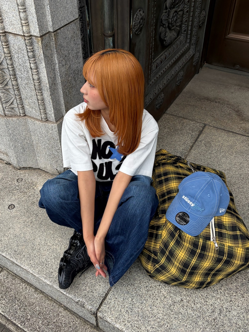 ホワイト系のTシャツ/カットソー、ブルー系のデニムパンツ、ブラック系のスニーカーを着用したレディースの春コーディネートの3枚目の写真
