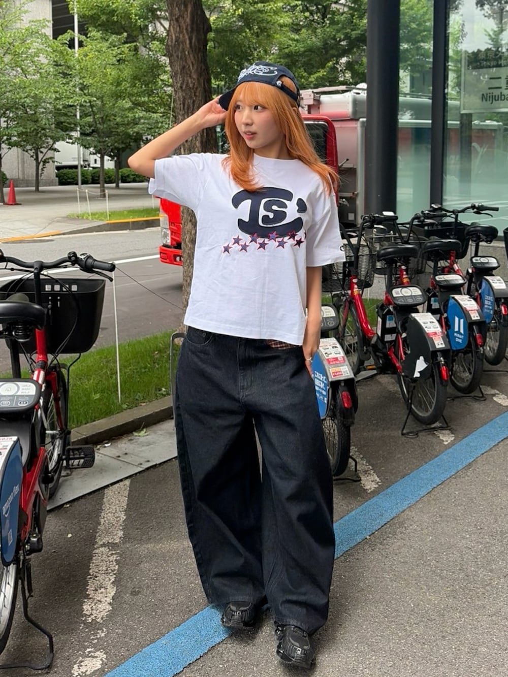 ブラック系のスニーカー、ホワイト系のTシャツ/カットソー、ブラック系のデニムパンツを着用したレディースの春コーディネートの3枚目の写真