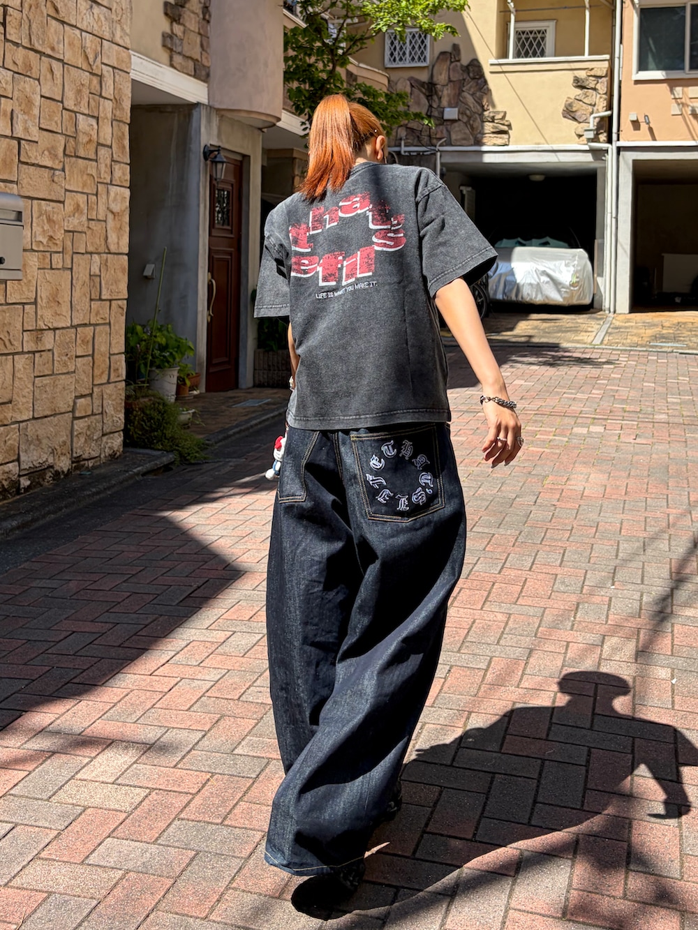 ブラック系のTシャツ/カットソー、ブラック系のデニムパンツ、ブラック系のスニーカーを着用したレディースの夏コーディネートの3枚目の写真